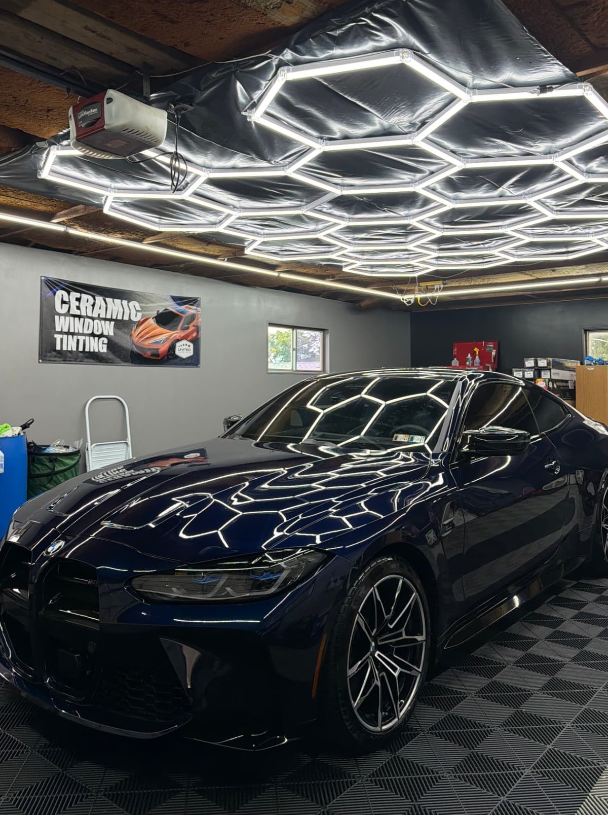 Navy BMW M4 after a JP Sudz detail, mirror gloss under hex lights